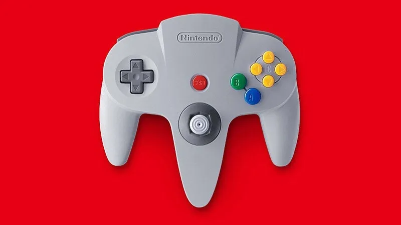 En grå Nintendo 64-kontroll mot en röd bakgrund.